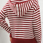 Woman wearing a burgundy and white striped long sleeve hooded sweater, showcasing a cozy and stylish look for chilly days.