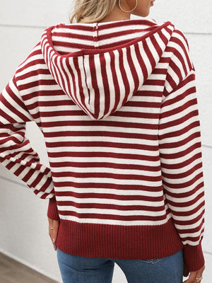 Woman wearing a burgundy and white striped long sleeve hooded sweater, showcasing a cozy and stylish look for chilly days.