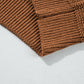 Close-up of brown textured sweater fabric with ribbed detail on cuffs.