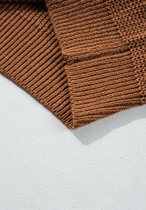 Close-up of brown textured sweater fabric with ribbed detail on cuffs.