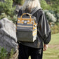 Fashionable striped waterproof nylon backpack with side pockets showcased outdoors by a hiker in nature.