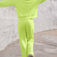 Person wearing lime Bella Road Set with round neck top and elastic waist pants walking outdoors, showcasing trendy comfort.