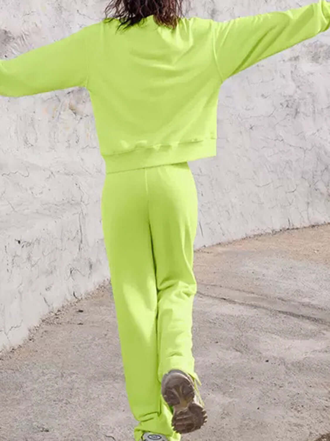 Person wearing lime Bella Road Set with round neck top and elastic waist pants walking outdoors, showcasing trendy comfort.