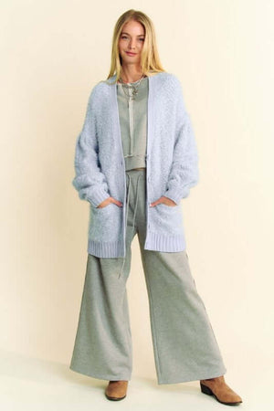 Model showcasing a light blue ribbed hem button-up cardigan over a cozy gray outfit, perfect for chic layering.