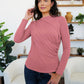 Woman wearing Dusty Pink FAM-FAM Ruched Mock Neck Long Sleeve T-Shirt indoors, styled with plants in the background