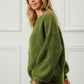 Model wearing a green diamond texture round neck long sleeve sweater, showcasing its cozy and stylish design.