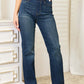 Woman wearing Judy Blue Jeans elastic waistband slim bootcut jeans with a snug fit and slight stretch standing in a room