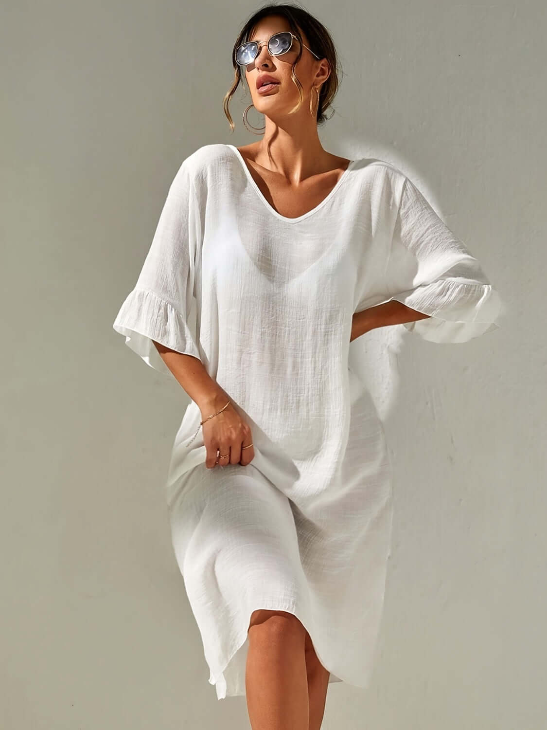 Woman wearing Slit V-Neck Flounce Sleeve Cover-Up in white, featuring backless design and sheer polyester material, ideal for beachwear.