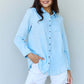 Woman wearing Blue Jean Baby Denim Button Down Shirt Top in Light Blue paired with white shorts.