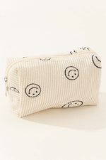 Small corduroy cosmetic pouch with smiley face design, perfect for storing makeup essentials on the go.