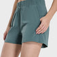 Millennia elastic waist active shorts in teal, featuring pockets and moderate stretch for comfort and versatility.