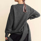 Stylish woman in a gray V-neck dropped shoulder sweater showcasing a cozy scarf, perfect for chic comfort.