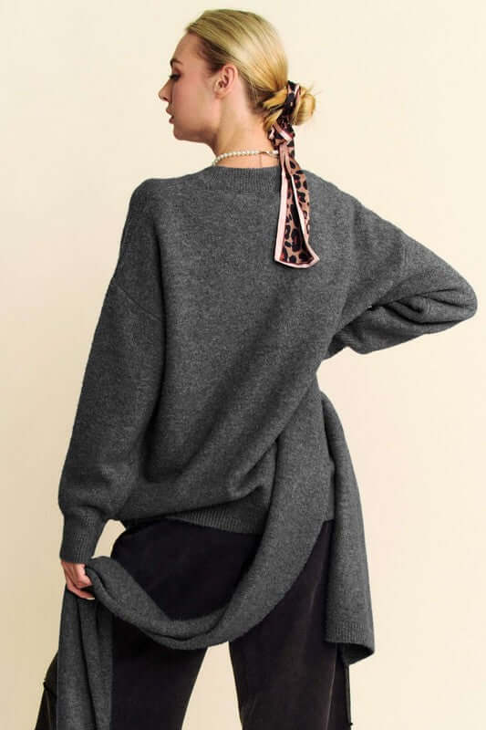 Stylish woman in a gray V-neck dropped shoulder sweater showcasing a cozy scarf, perfect for chic comfort.