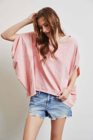 Woman wearing HEYSON garment-dyed oversized boat neck top with denim shorts, showcasing a relaxed and chic style.