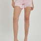 Pink high rise distressed denim shorts by Risen Jeans styled with black heels for a chic summer look.