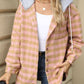 Woman wearing Bella Road Drawstring Plaid Long Sleeve Hooded Jacket, holding a coffee cup, styled in casual outfit with jeans and hat.