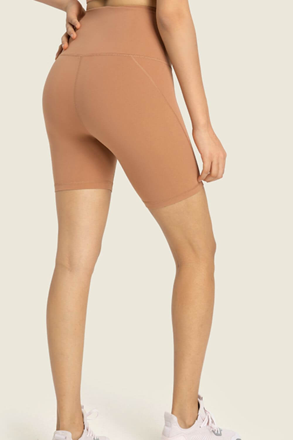 Back view of Millennia Seamless High-Rise Biker Shorts in soft tan, ideal for workouts and lounging in style.