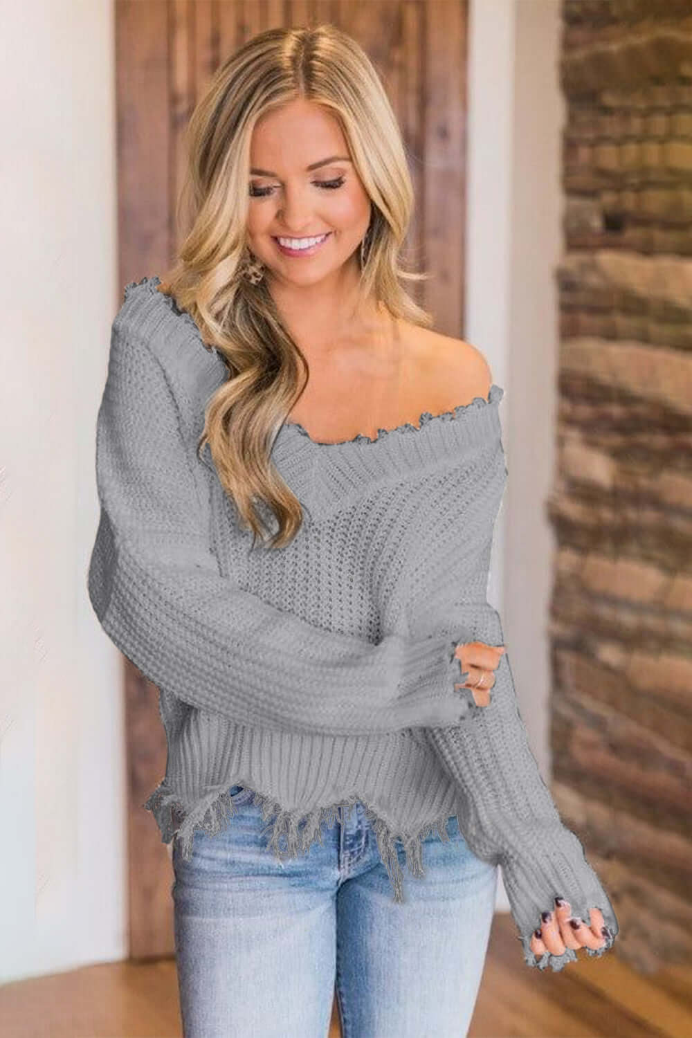 Woman wearing Bella Road Frayed Hem Dropped Shoulder Sweater in gray, exuding casual style and comfort.