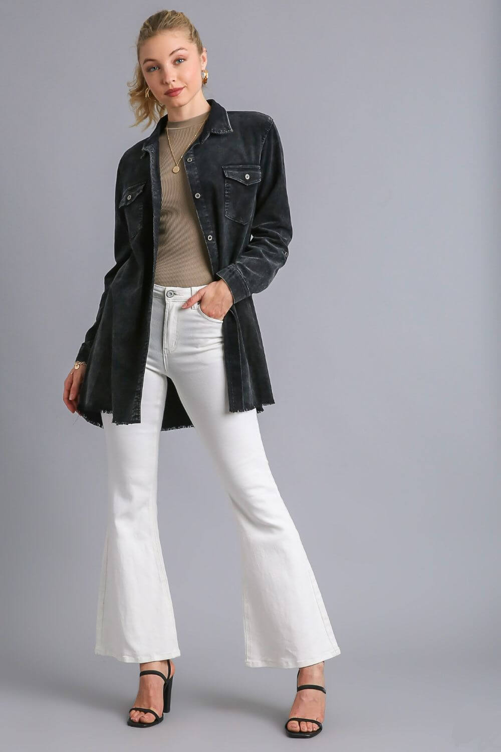 Model showcasing Umgee raw hem button down denim jacket with chest pockets, paired with white flared pants and stylish heels.