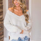 Woman in Bella Road frayed hem sweater with dropped shoulders, adding quirky fun to a stylish and comfortable look.