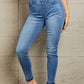 Woman wearing Janavie full-size high-waisted pull-on Judy Blue skinny jeans with release hem detailing