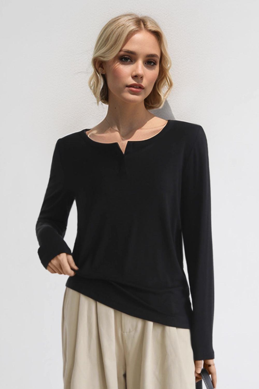 Woman wearing Basic Bae Notched Long Sleeve T-Shirt in black, showcasing a chic notched neckline and comfy fit.