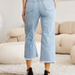 Woman wearing RFM Tummy Control High Waist Raw Hem Distressed Jeans in a living room.