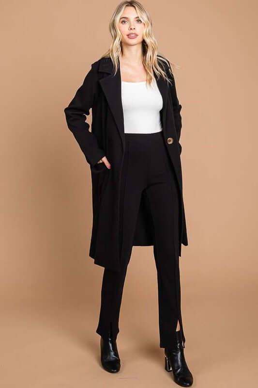 Stylish model in a black double-breasted coat and fitted pants, showcasing elegance and versatility.