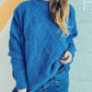 Woman wearing Bella Road Diamond Round Neck Long Sleeve Sweater in blue with unique diamond pattern and jeans