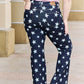 Woman wearing Janelle Full Size High Waist Star Print Flare Jeans in dark wash finish by Judy Blue Jeans