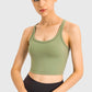 Stylish model wearing a Millennia Racerback Sports Bra in olive green, perfect for yoga and workouts.