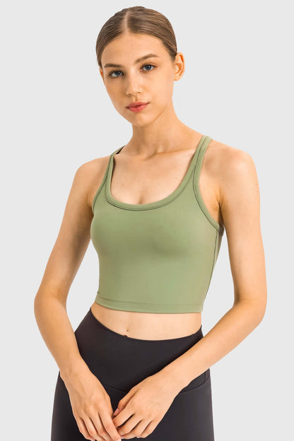 Stylish model wearing a Millennia Racerback Sports Bra in olive green, perfect for yoga and workouts.