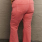 Woman wearing Bailey High Waist Side Slit Flare Jeans in pink with raw hem, showcasing stylish side slits and flattering high-rise fit.