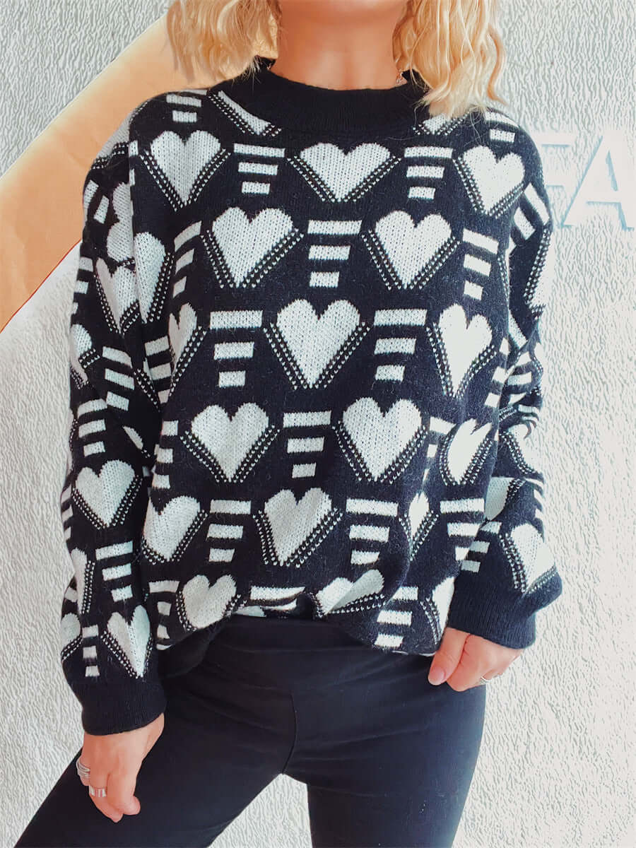 Woman wearing Bella Road Heart Contrast Long Sleeve Dropped Shoulder Sweater in black and white hearts pattern.