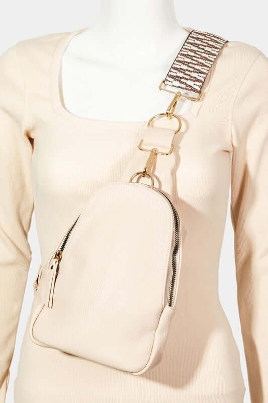 Chic beige faux leather sling bag with stylish single strap on a mannequin, perfect for everyday essentials.