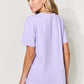 Woman wearing a lavender MAMA round neck short sleeve T-shirt, showcasing the back view of the shirt.