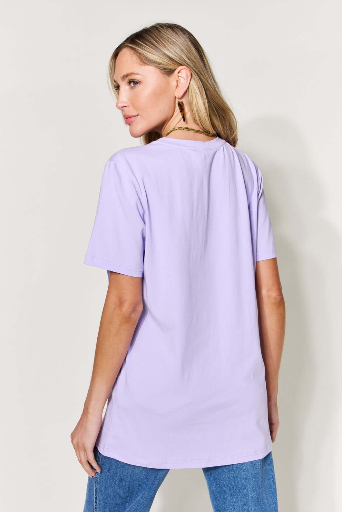 Woman wearing a lavender MAMA round neck short sleeve T-shirt, showcasing the back view of the shirt.