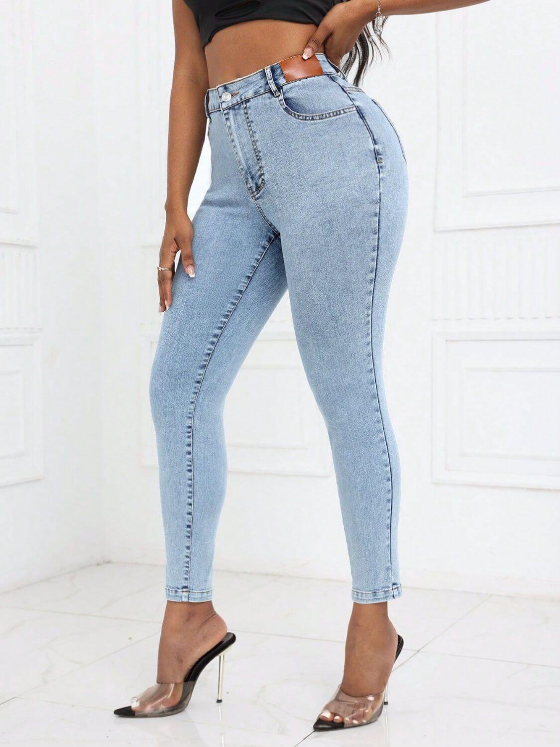 Woman modeling Bella Road High Waist Skinny Jeans with Pockets in light blue, paired with black top and high heels.