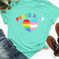 Aqua round neck short sleeve t-shirt with "Proud Ally" text and heart design, paired with jeans and sandals on a white background.