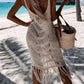 Woman in khaki Bella Road Swim Fringe Cover-Up with fringe detailing, enjoying a beach day with a bag in hand.