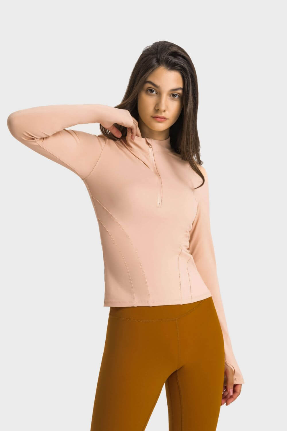 Model showcasing the Millennia Half Zip Thumbhole Sleeve Sports Top in soft pink, perfect for yoga and workouts.