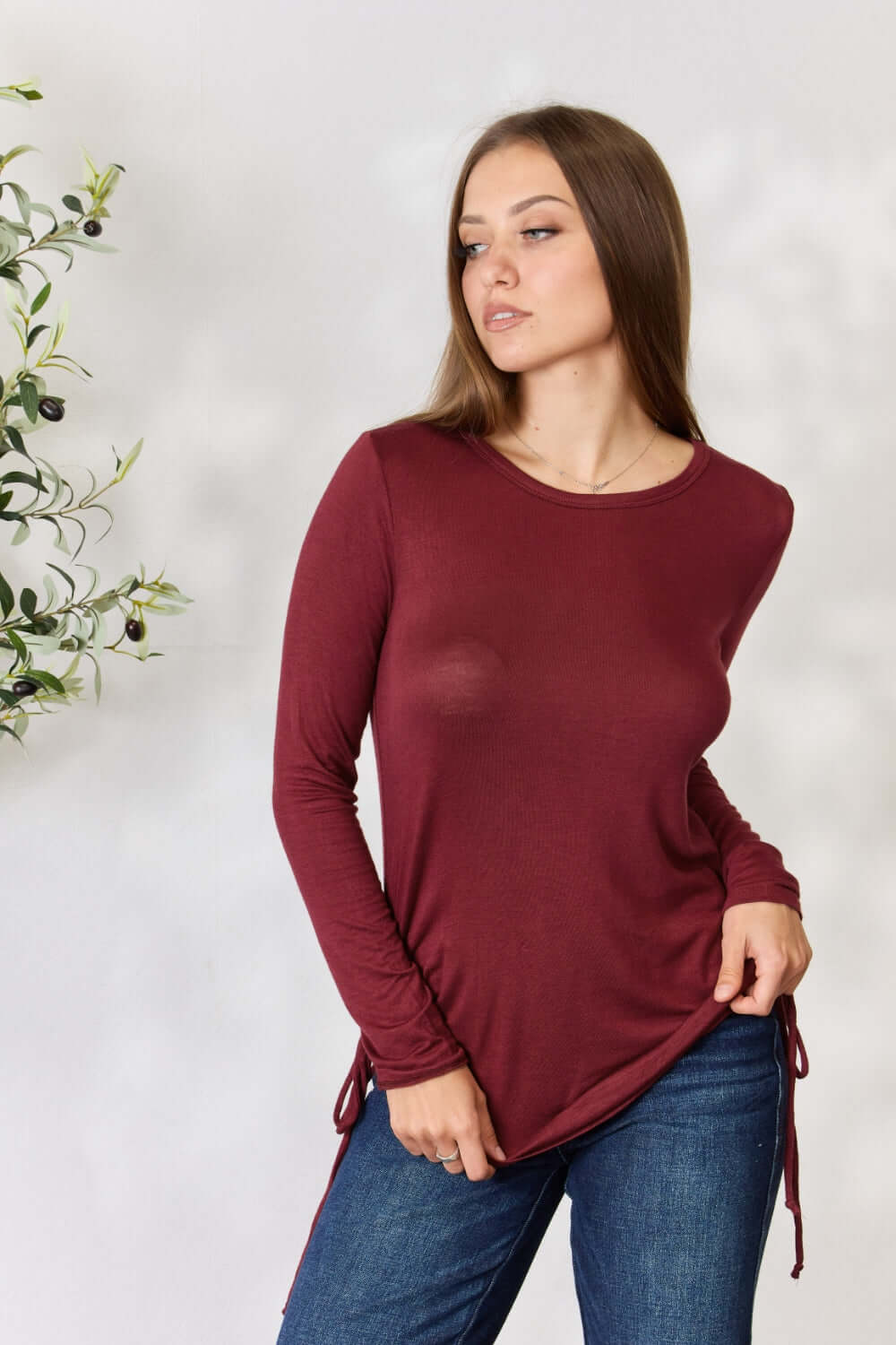 Woman wearing burgundy drawstring round neck long sleeve top