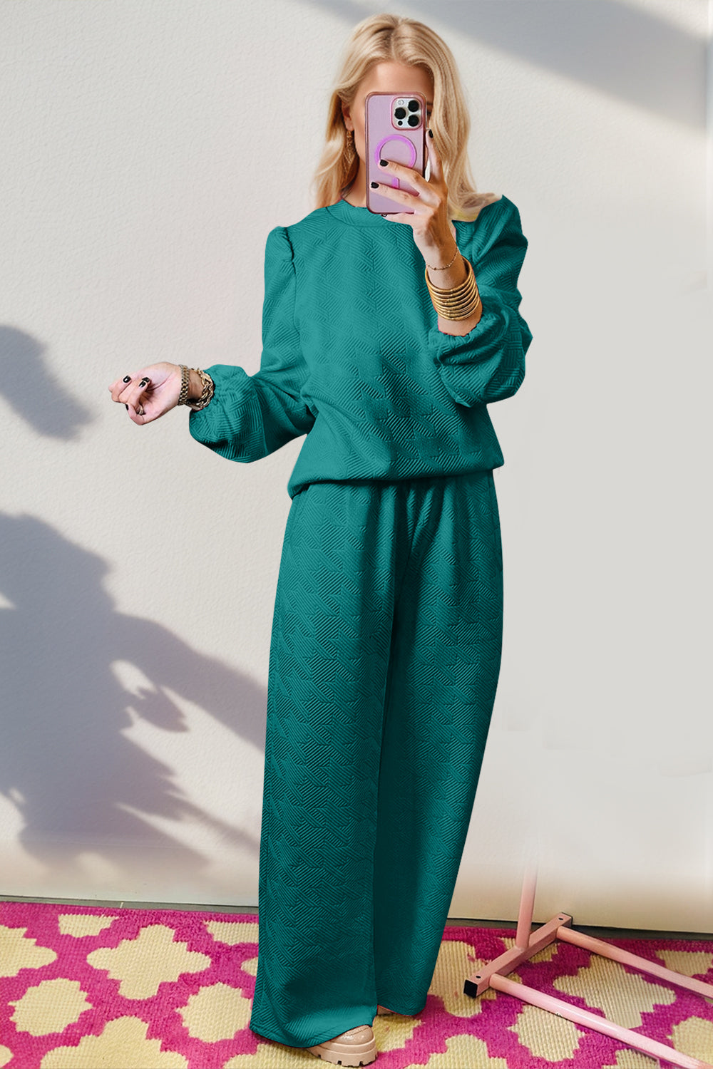 Stylish woman in teal Double Take Texture long sleeve top and wide leg pants set, showcasing quirky and playful fashion.