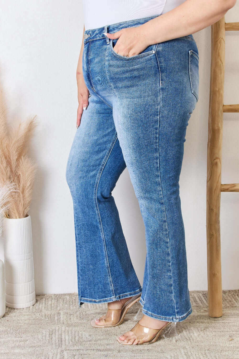 Woman wearing Risen Jeans high rise ankle flare jeans, showing flattering fit and versatile style, paired with clear high heel shoes.