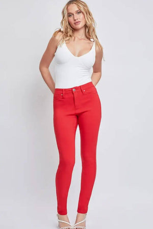 Woman wearing red Hyperstretch Mid-Rise Skinny Jeans by YMI Jeans with a white top, displaying a sleek and modern style.