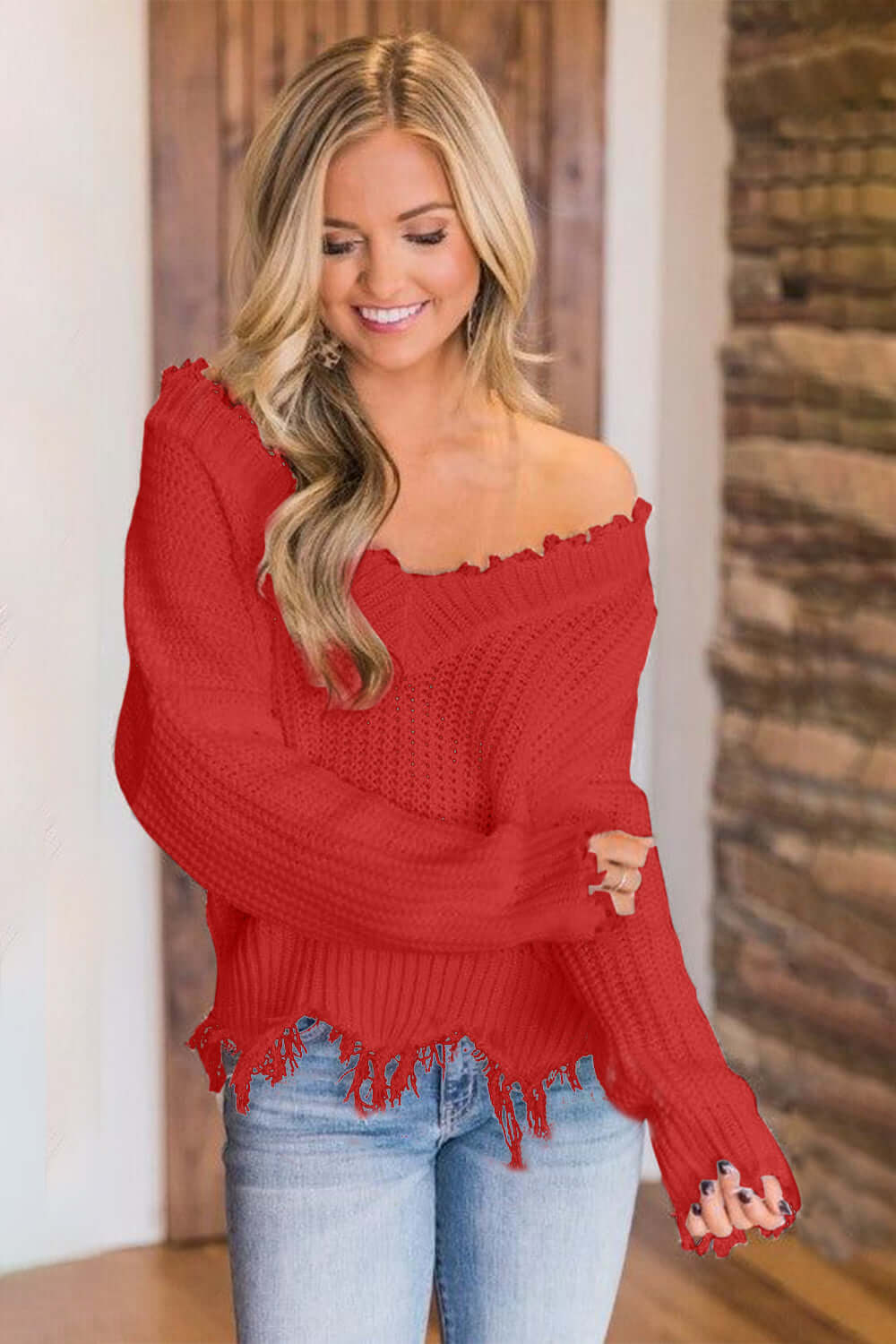 Woman wearing Bella Road frayed hem dropped shoulder sweater in red, cozy and stylish look