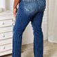 Back view of model wearing Judy Blue Mid Rise Hand Sand & Destroy Bootcut Jeans Petite in a distressed style and slightly stretchy material