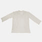 Cream ribbed long sleeve sweater laid flat on a white background, showcasing its cozy, textured fabric.