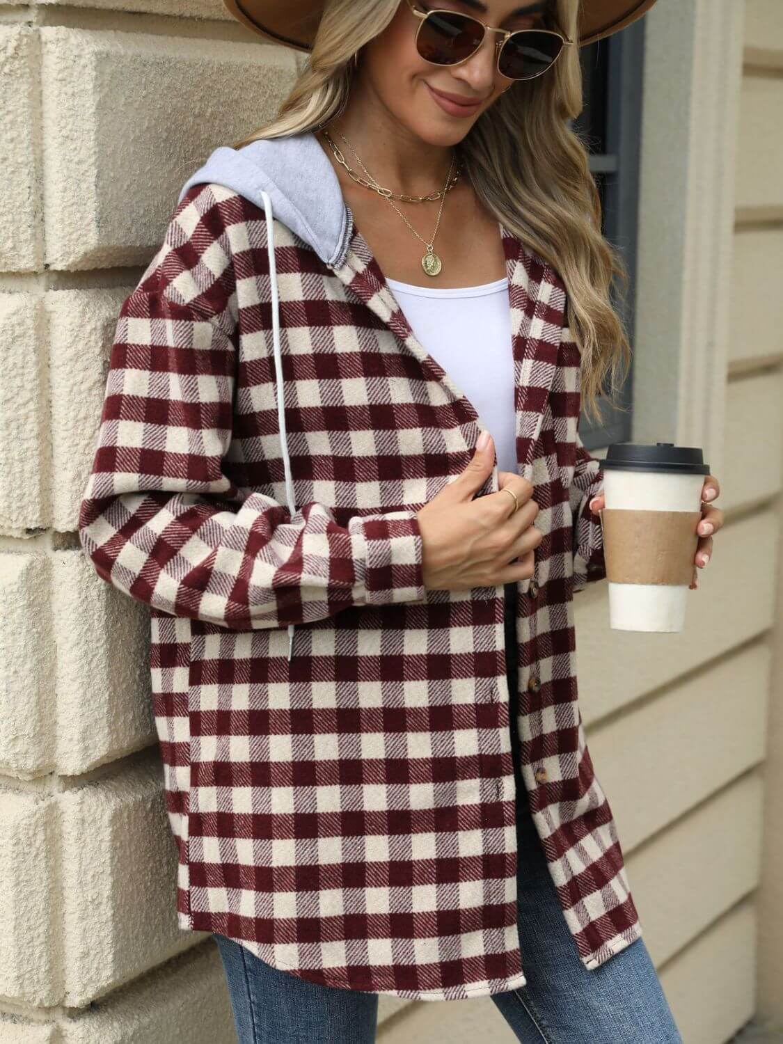 Woman wearing Bella Road Drawstring Plaid Long Sleeve Hooded Jacket holding a coffee cup.