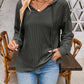 Woman wearing drawstring dropped shoulder long sleeve hoodie in charcoal gray with casual blue jeans.